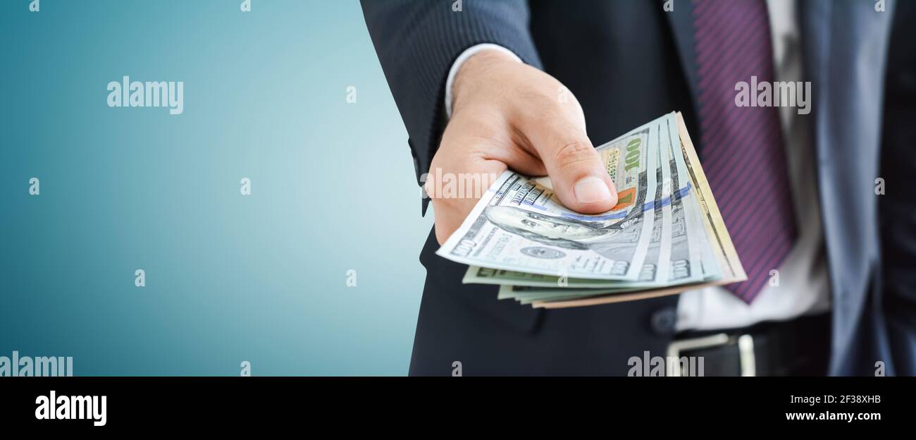 Geschäftsmann Geld geben, US-Dollar (USD) Rechnungen, auf grauem Hintergrund - Panorama finanziellen Hintergrund Konzept Stockfoto