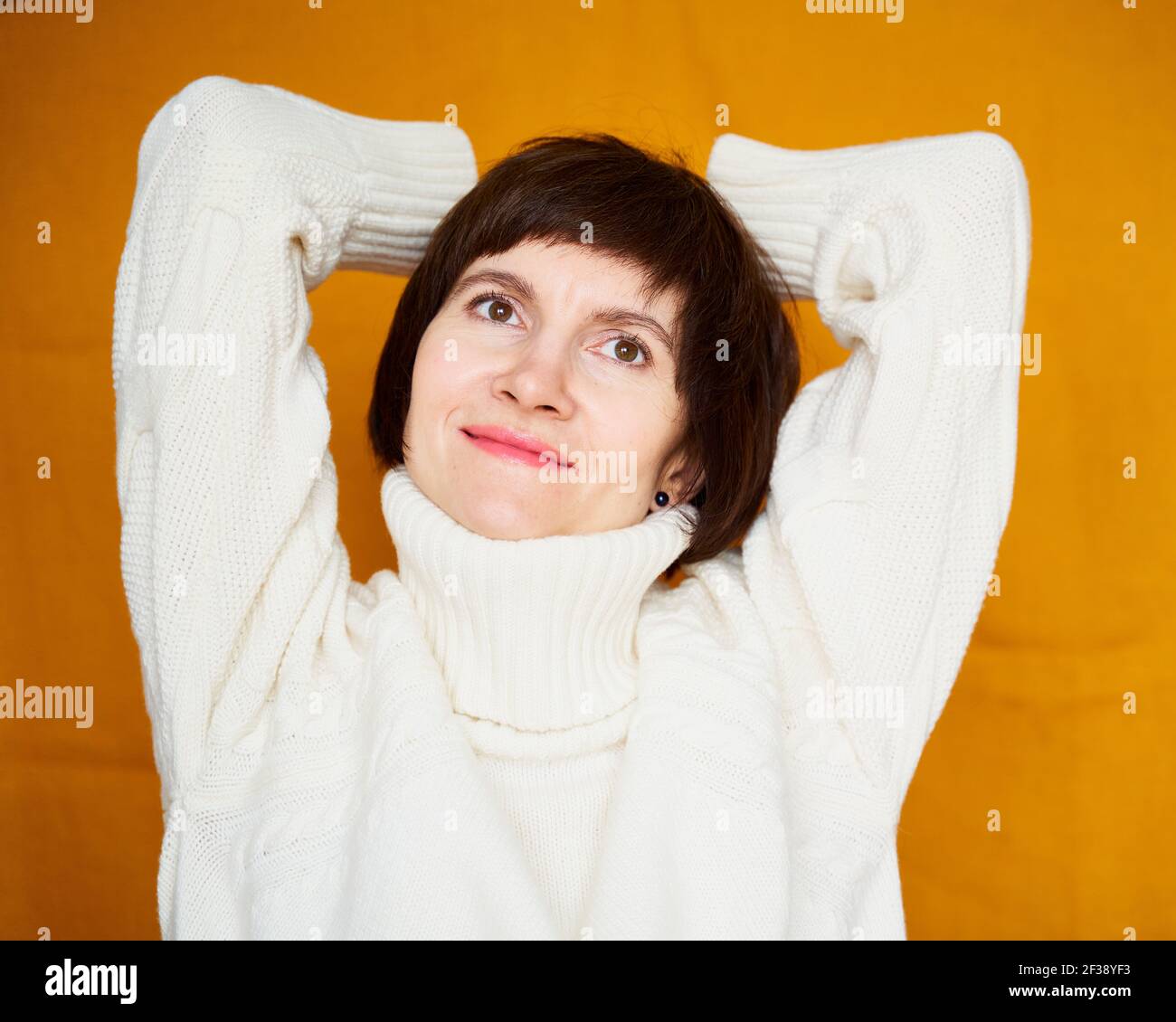 Portrait der reifen Frau zufrieden mit sich selbst, lächelnd und träumend mit Selbstreflexion Stockfoto
