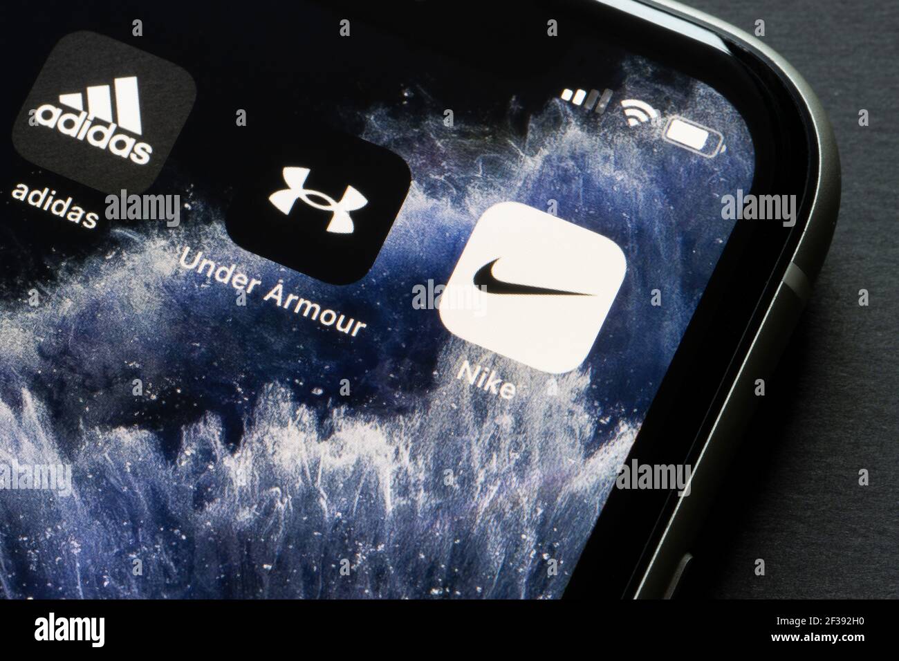 Die mobilen Apps von Nike, Under Armour und Adidas sind auf einem iPhone zu sehen. Die drei Unternehmen sind die größten Einzelhändler im Wettbewerb... Stockfoto