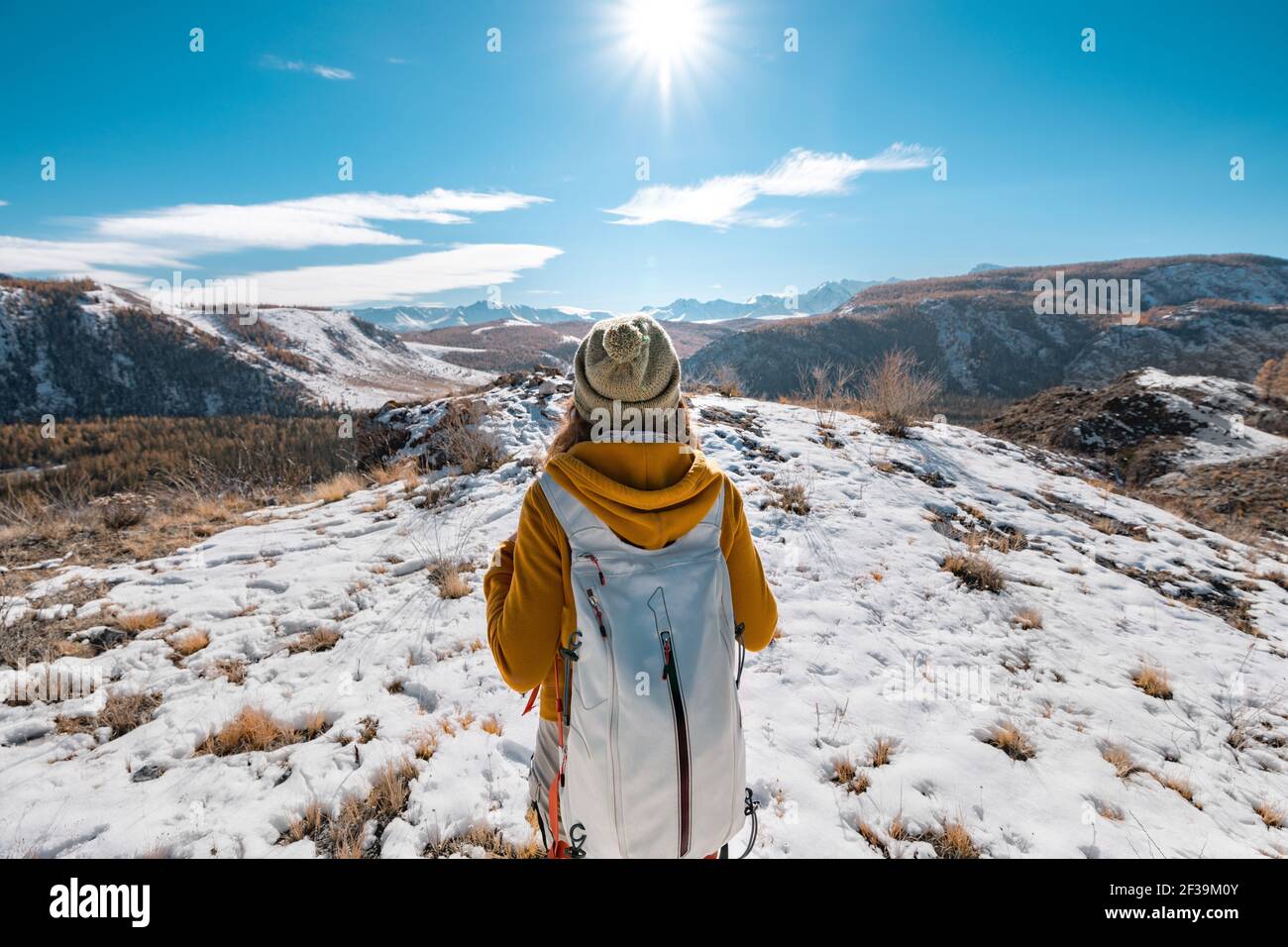 Ein Wanderer pausiert für Kontemplation auf einem knackigen und verschneiten Tag in den Bergen Stockfoto