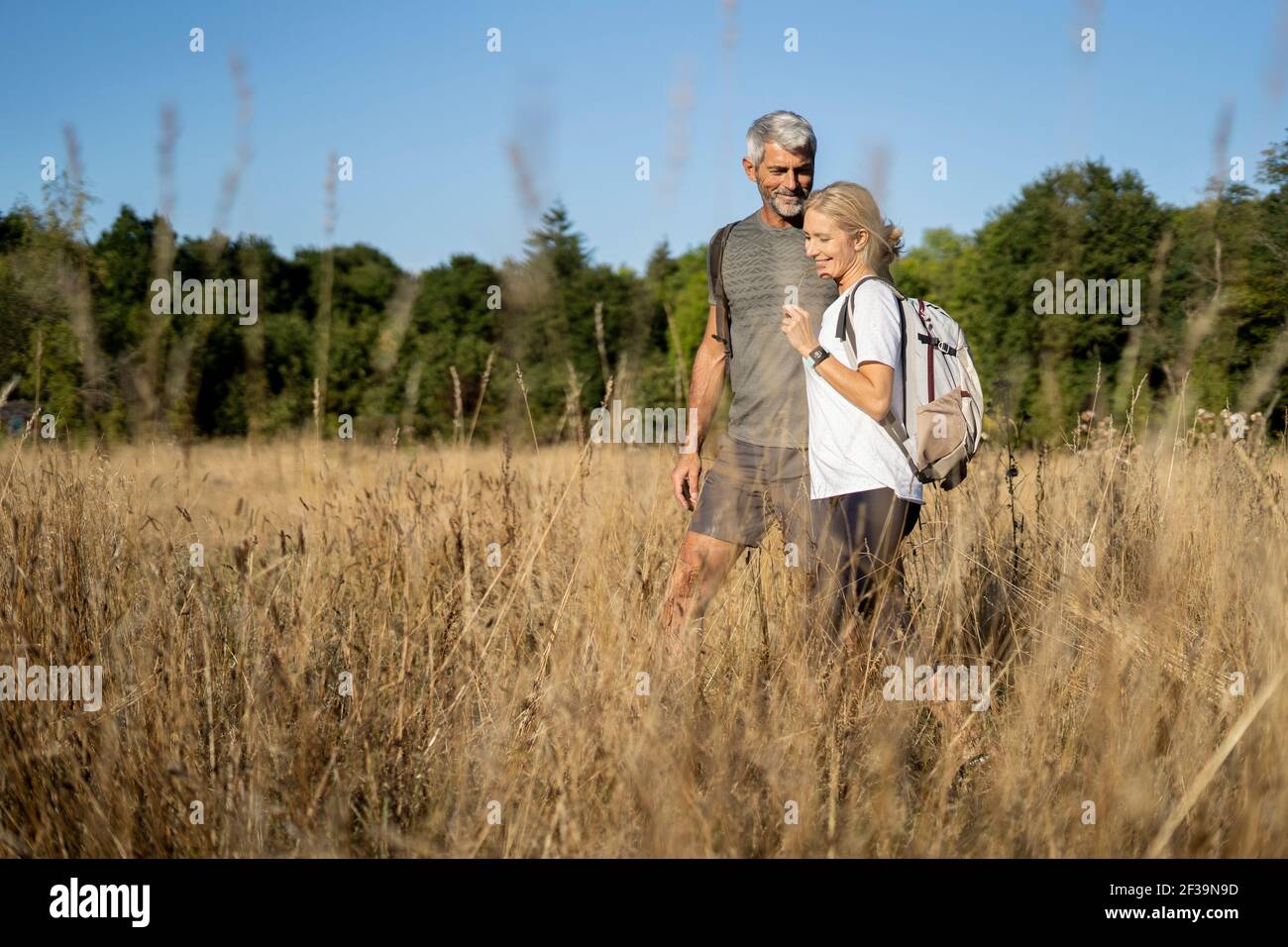 Lächelndes reifes Paar beim Wandern im Wald Stockfoto