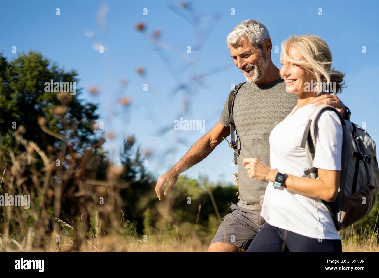 Lächelndes reifes Paar beim Wandern im Wald Stockfoto