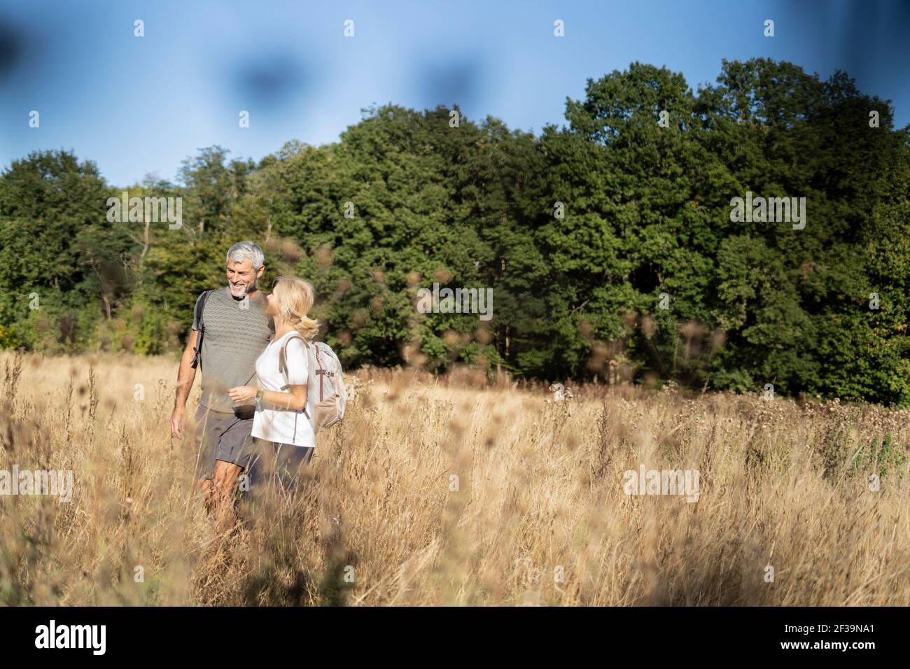 Lächelndes reifes Paar beim Wandern im Wald Stockfoto