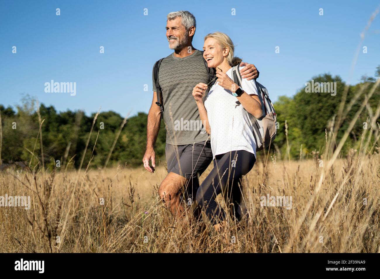 Lächelndes reifes Paar beim Wandern im Wald Stockfoto