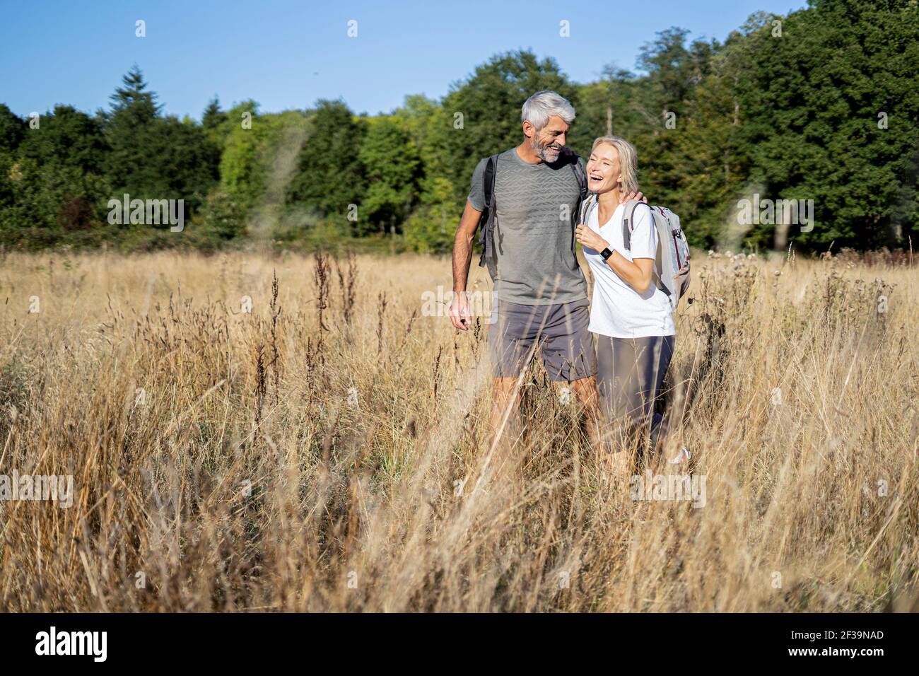 Lächelndes reifes Paar beim Wandern im Wald Stockfoto
