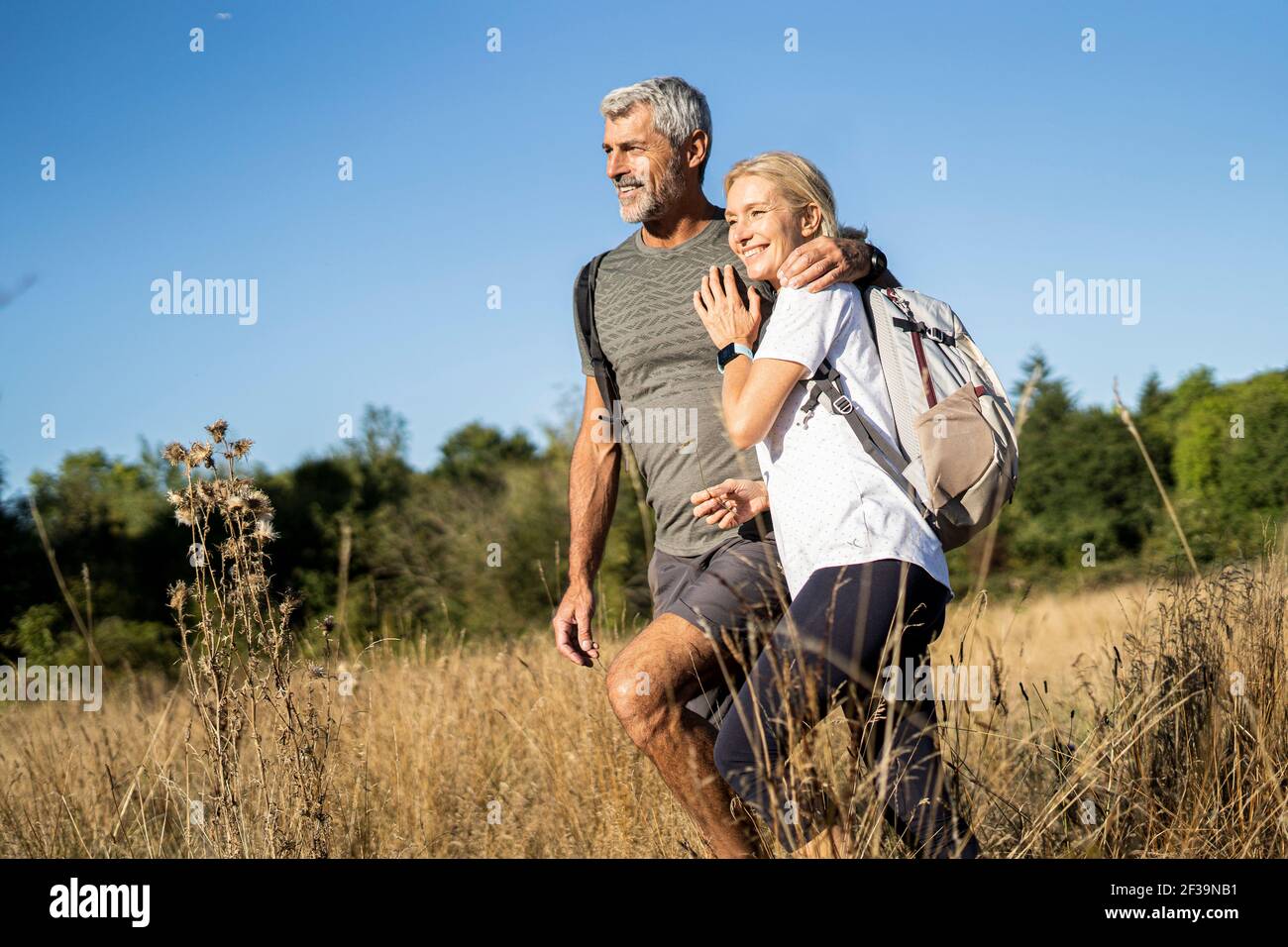 Lächelndes reifes Paar beim Wandern im Wald Stockfoto