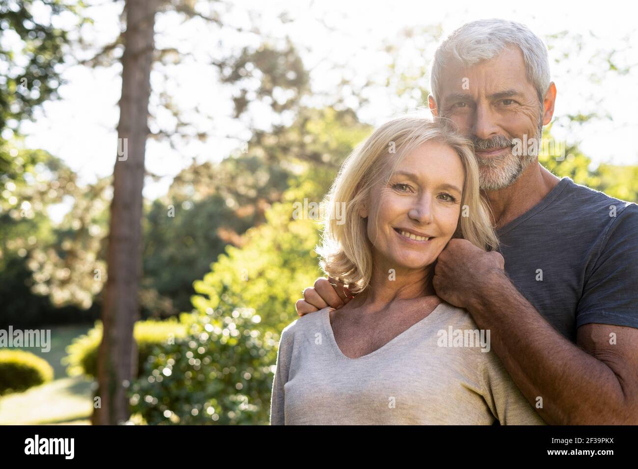 Porträt eines lächelnden reifen Paares, das im Hinterhof steht Stockfoto