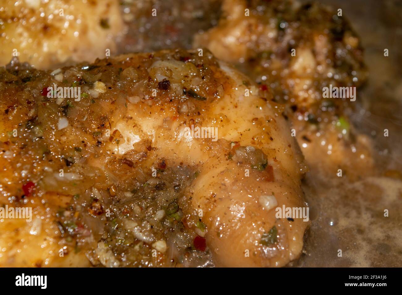 Kleine Stücke Hühnerfleisch werden mit Gewürzen geschmort. Nahaufnahme mit selektivem Fokus. Stockfoto