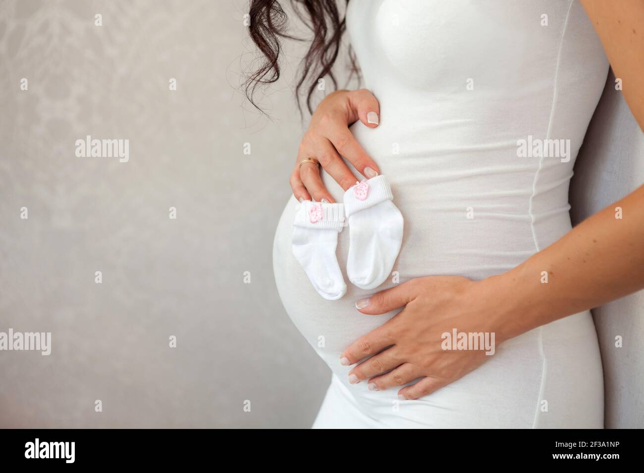 Schwangerer Bauch Nahaufnahme. Ein Paar hält den Bauch einer schwangeren Frau. Mutterschaftskonzept. Platz für Text kopieren. Neues Lebenskonzept. Stockfoto