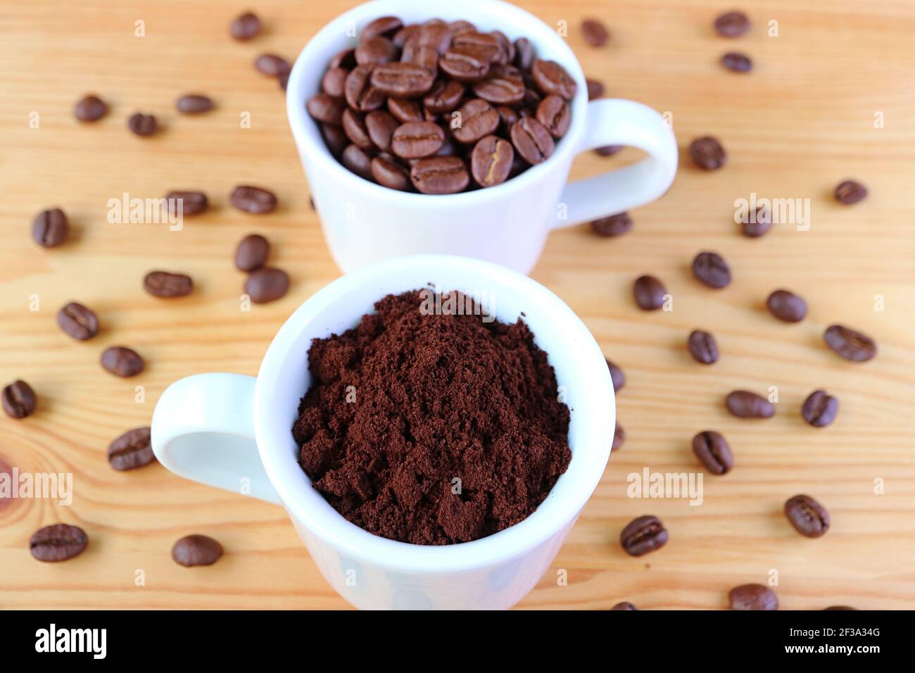 Tasse gemahlener Kaffee mit einer Tasse geröstetem Kaffee Bohnen im Hintergrund Stockfoto