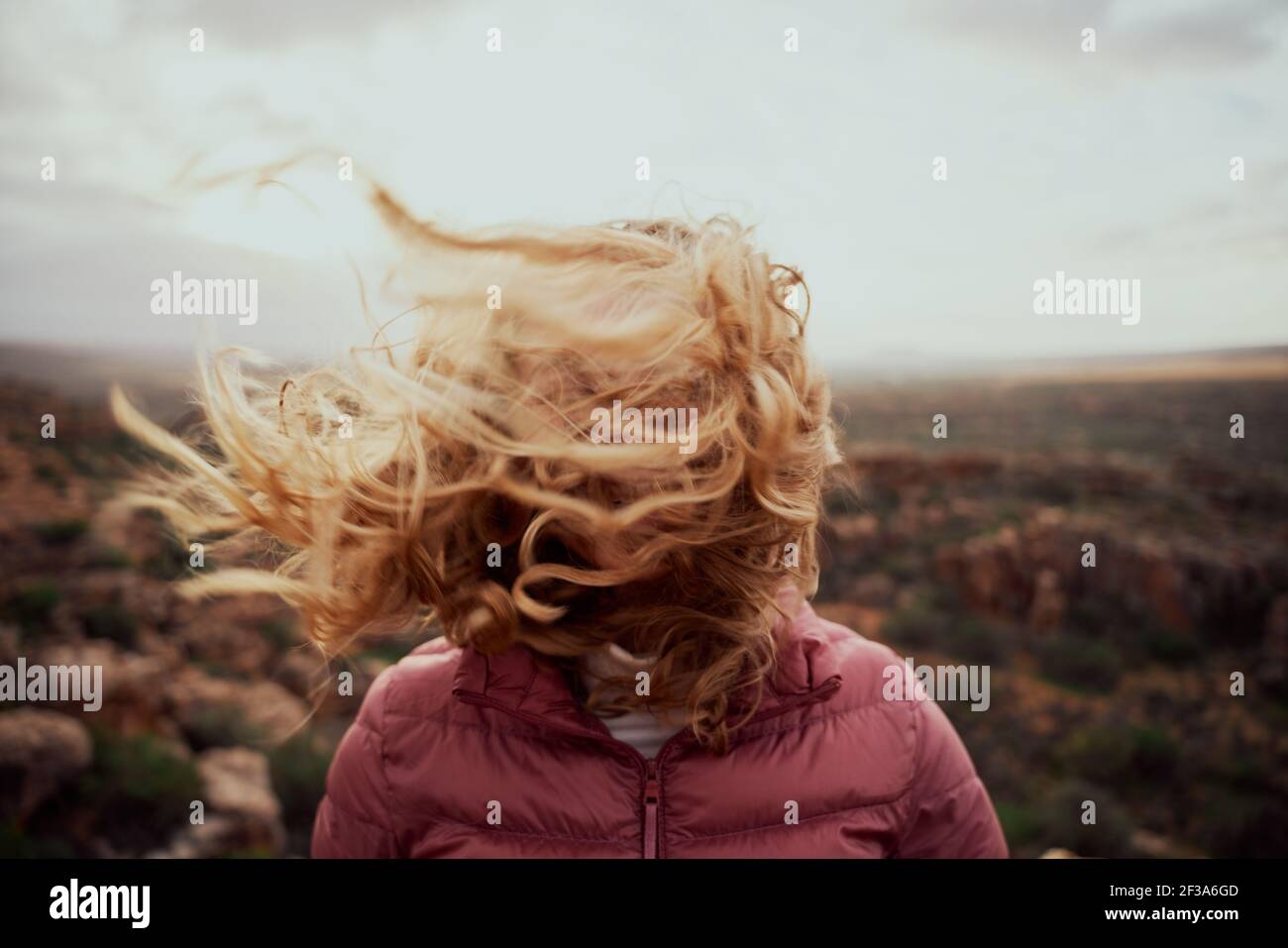 Nahaufnahme der jungen Frau Gesicht mit fliegenden Haaren in bedeckt Windiger Tag steht am Berg Stockfoto