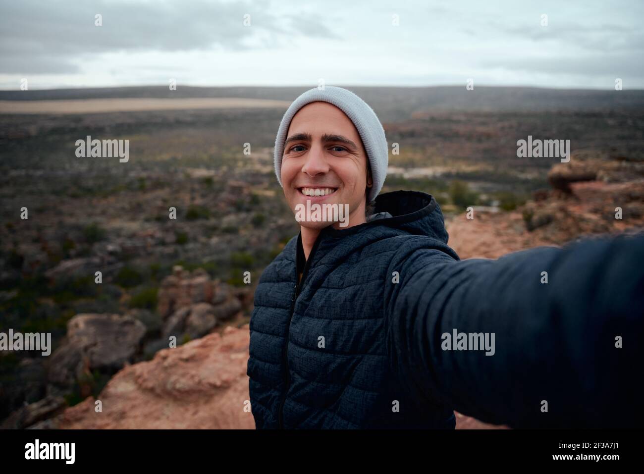 Porträt eines glücklichen und lächelnden Wanderers, der ein Selfie macht Die Spitze des Berges Stockfoto