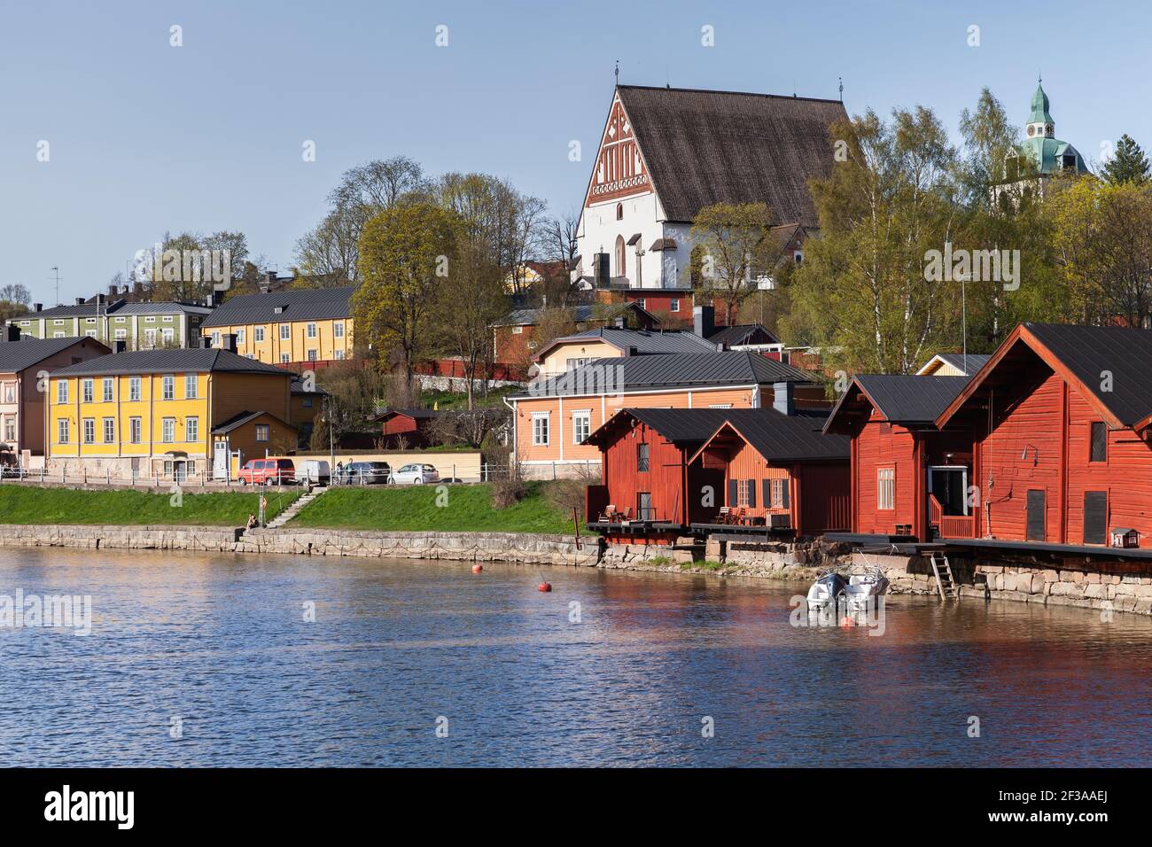 Porvoo, Finnland - 7. Mai 2016: Altstadt von Porvoo, Finnland. Sommerlandschaft mit roten Holzhäusern an der Flussküste und der Kathedrale von Porvoo auf einem Hintergrund Stockfoto