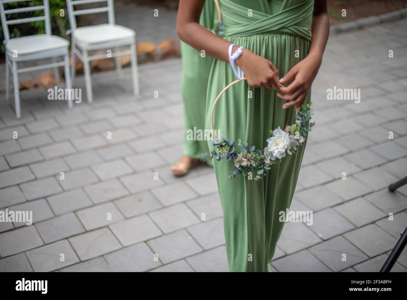 Kurzer Schuss von Brautjungfer mit Blumen zu Fuß Stockfoto
