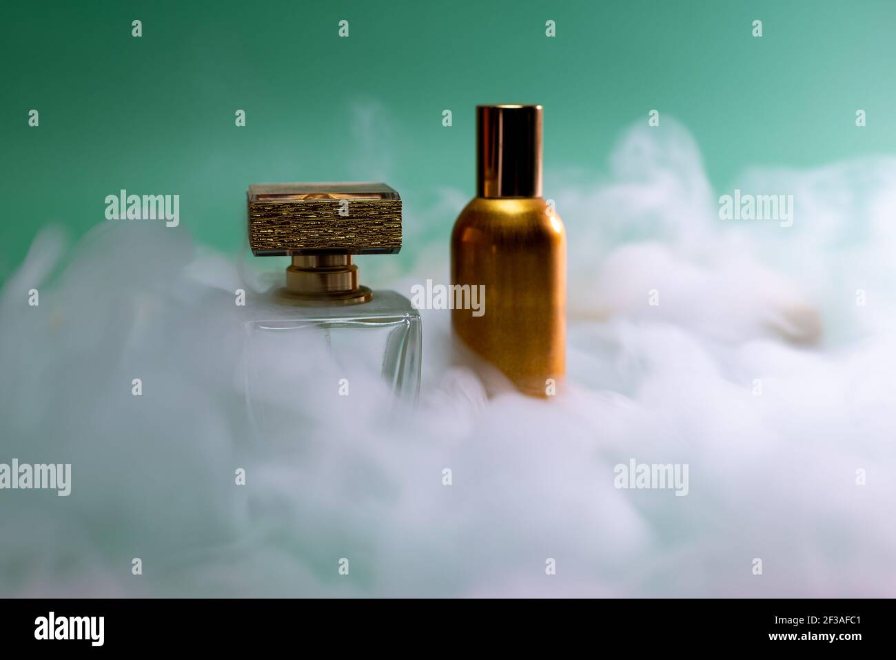 Damenparfüm auf grünem Hintergrund, in Dampf gehüllt Stockfoto