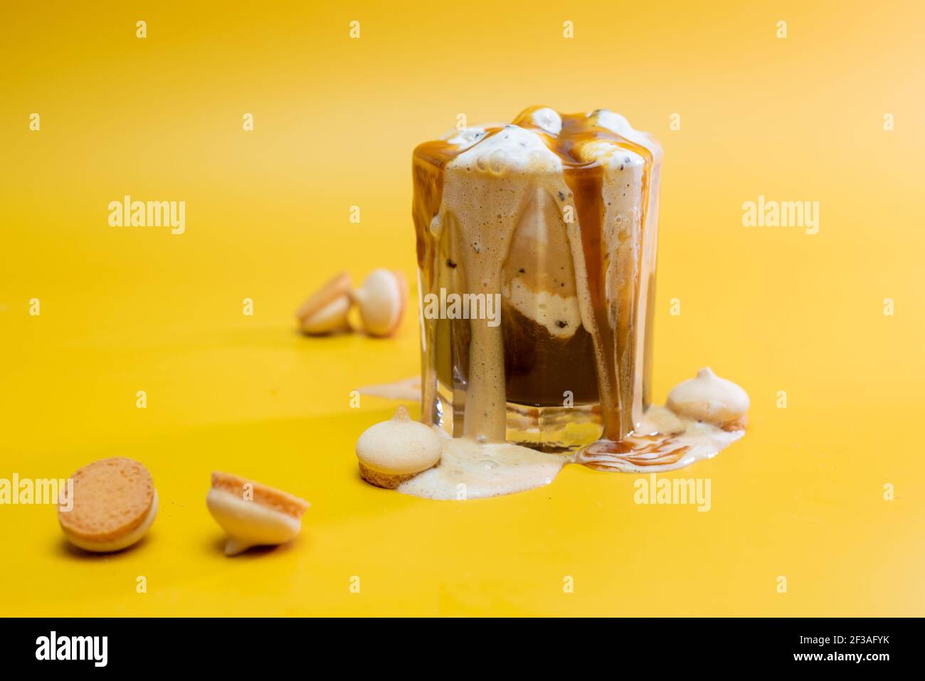 Kaffeegetränk mit zarter Marmelade und fließenden Schaum auf einem Gelber Hintergrund Stockfoto