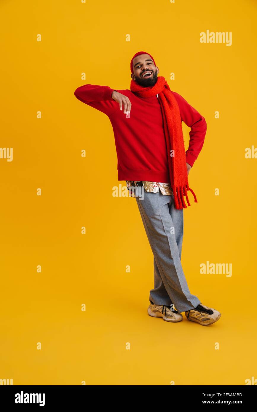 Porträt von entspannten jungen afrikanischen Mann lehnt an einer gelben Wand Hintergrund, voller Länge Stockfoto