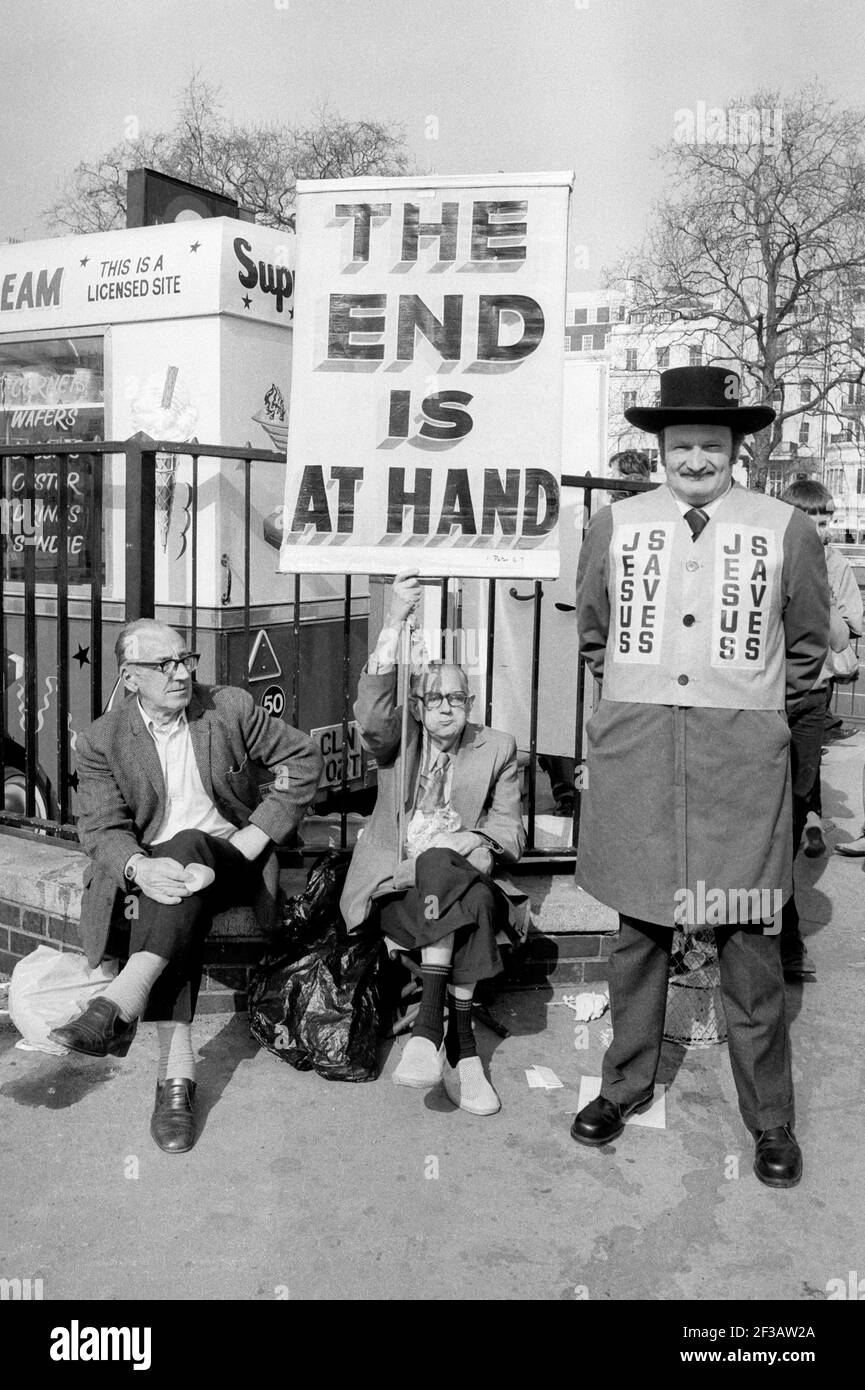 Drei ältere Männer in der Nähe von Speakers Corner im Hyde Park London England Großbritannien das Ende trägt Banner und Jesus rettet Jacke fotografiert im Jahr 1984. Stockfoto