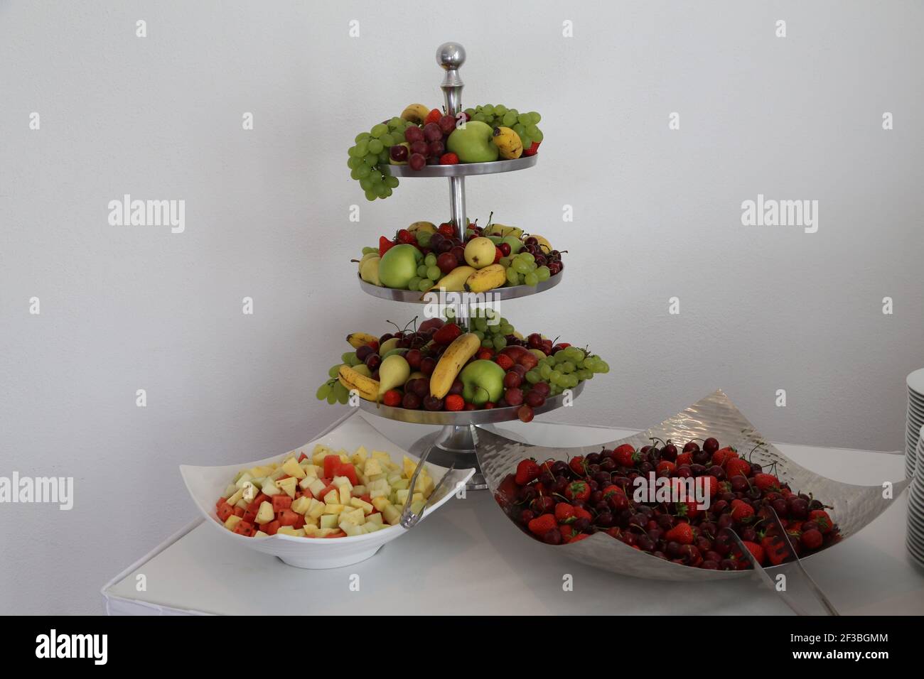 Eine Portion frisches, leckeres Obst in Schüsseln und Tellern Stockfoto