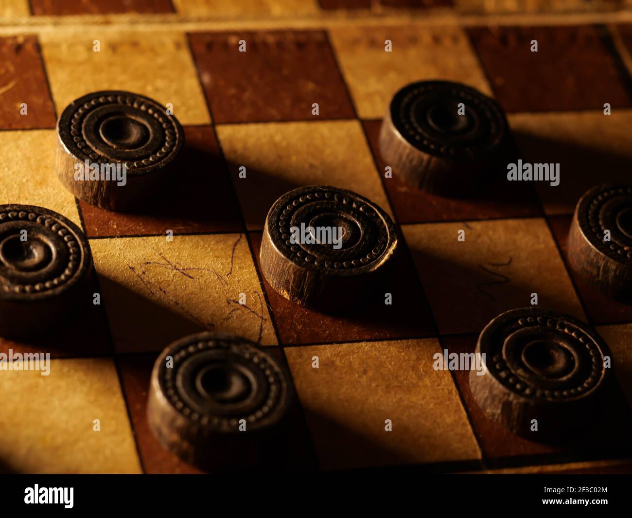 Vintage Holzschachbrett mit braunen und cremefarbenen Steinen. Stockfoto