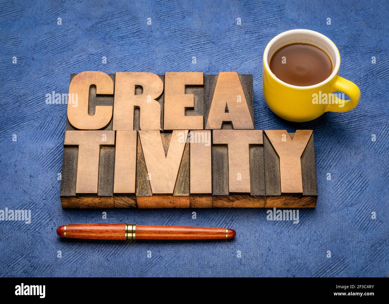 Kreativität Wort abstrakt in vintage Buchdruck Holzart Druckblöcke gegen strukturierte, handgemachte Papier mit einer Tasse Kaffee, Kunst, Geschäft, eduda Stockfoto