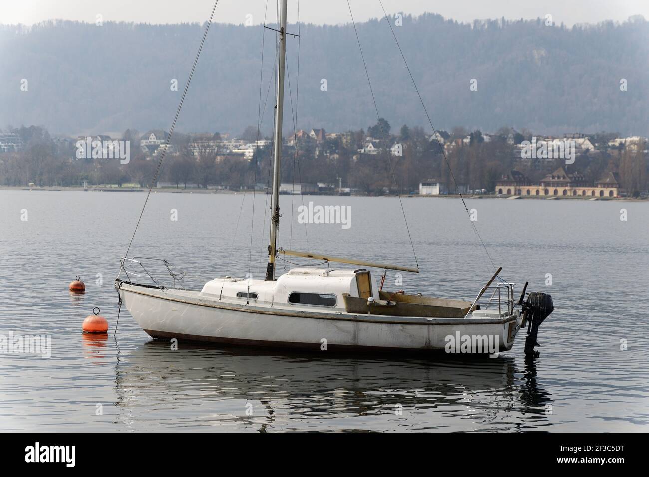 Altes Interessantes Boot mit schwarzem Außenbordmotor schwimmt führerlos auf dem Wasser, der Anker wurde gelegt Stockfoto