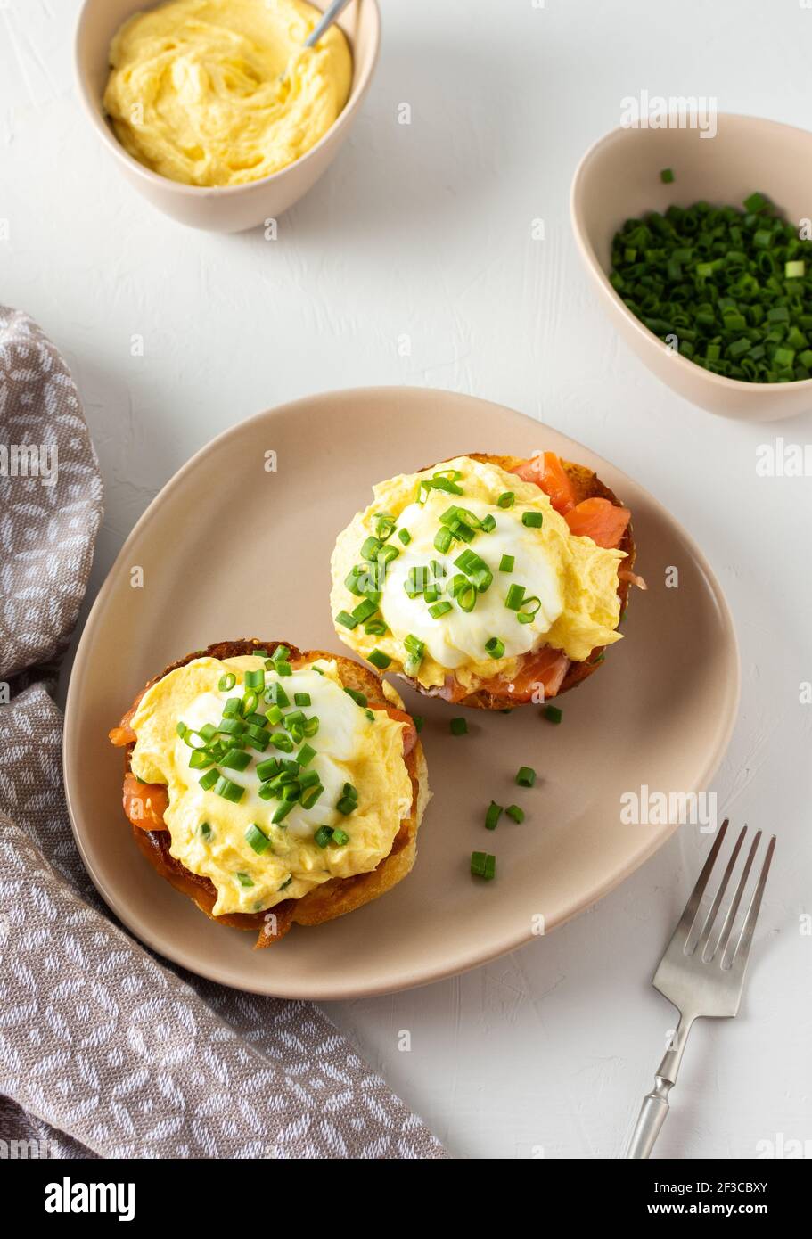 Leckeres herzhaftes Frühstück, Eier Atlantic in einem Teller auf weißem Hintergrund, Runde gebratene Brötchen mit Lachs und Eier Benedikt, Sauce Hollandaise Stockfoto