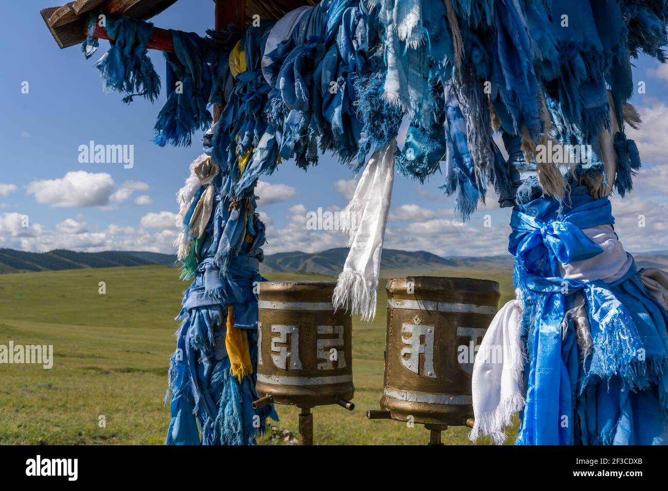 Ovoo Buddhismus mit blauen Khadags auf der Steppe der Mongolei in den Hügeln. Stockfoto