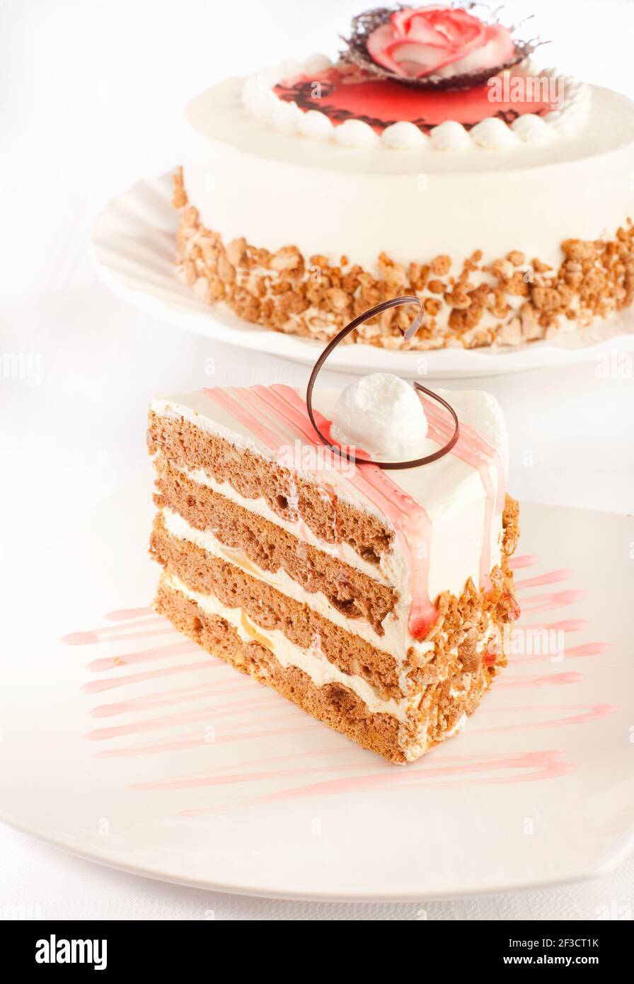 Ein gestylter Kuchen und ein Stück davon davor. Stockfoto