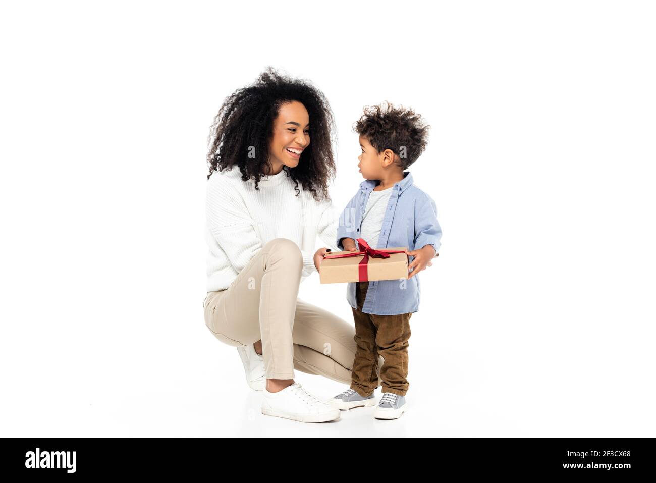 Glückliche afroamerikanische Mutter, die auf Kleinkind Sohn hält Gegenwart Auf Weiß Stockfoto