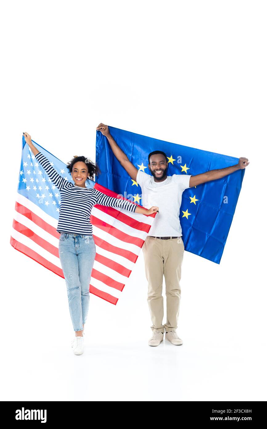 Fröhliches afroamerikanisches Paar, das die flaggen der usa und der europäischen Union hält Auf Weiß Stockfoto