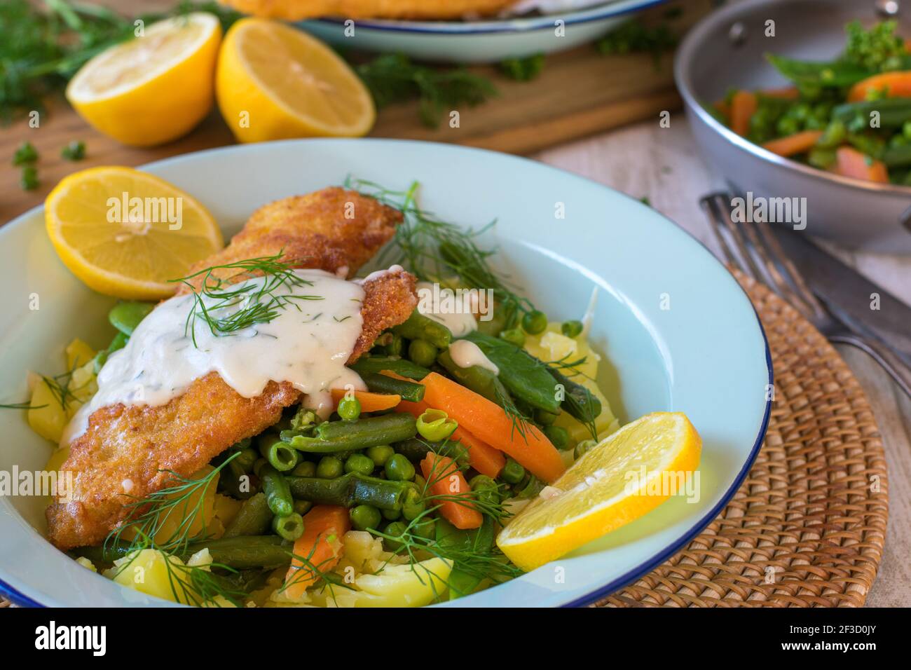 Panierter Fisch mit Gemüse auf einem Teller Stockfoto