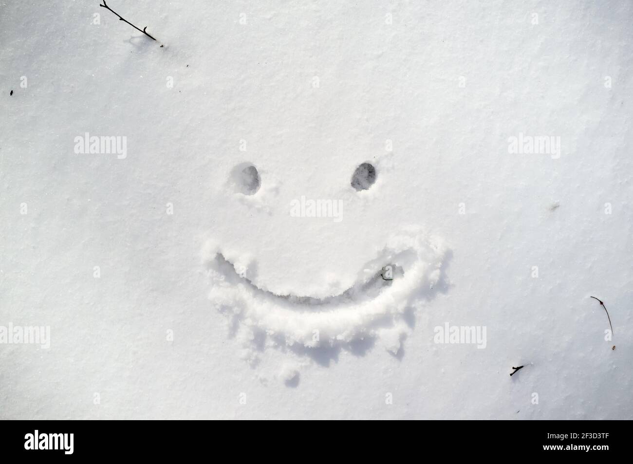 Nettes Smiley Gesicht gezeichnet auf Schnee im Wintertag. Stockfoto