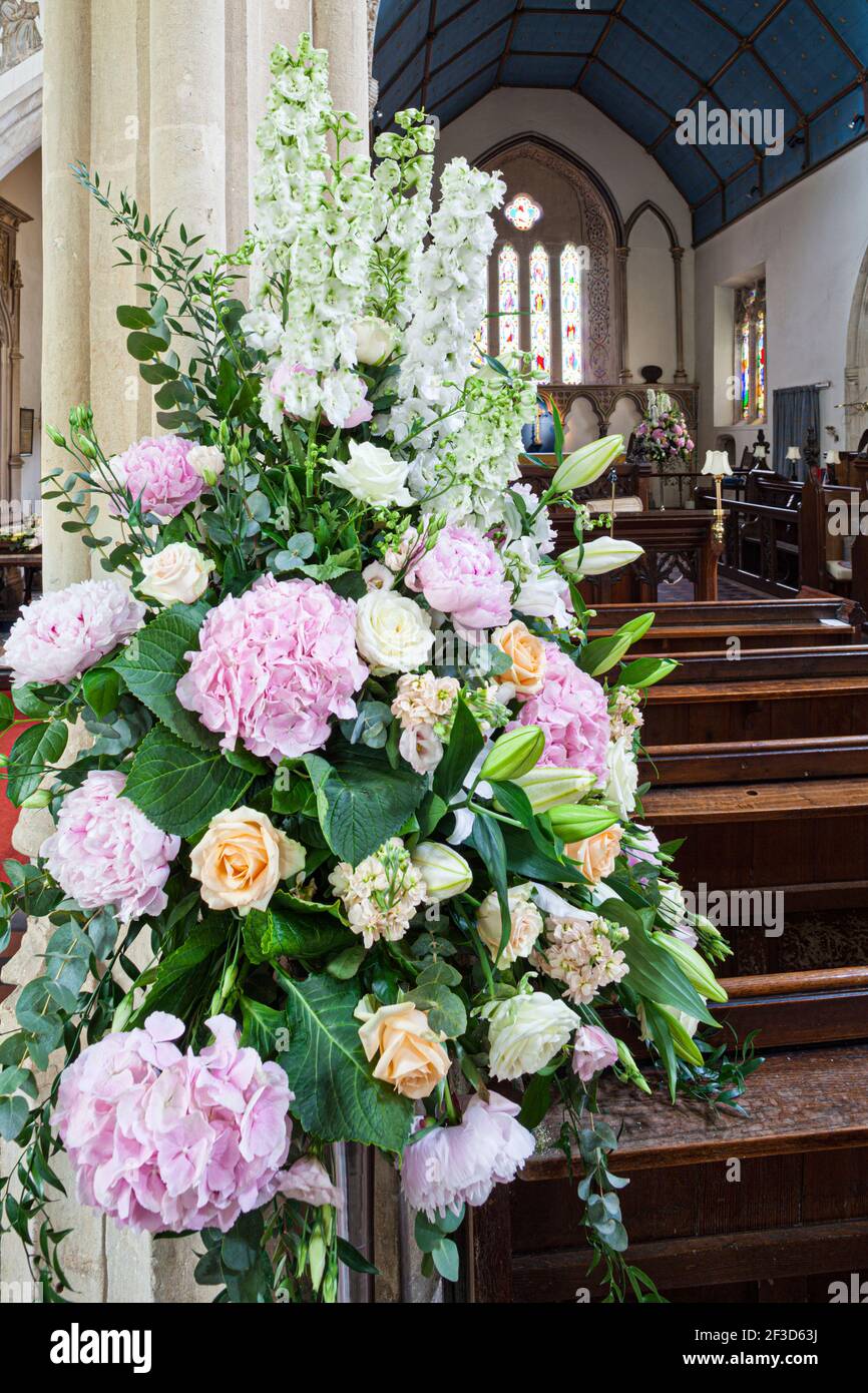 Blumen in St. Andrews Kirche im Cotswold Dorf Castle Combe, Wiltshire UK Stockfoto