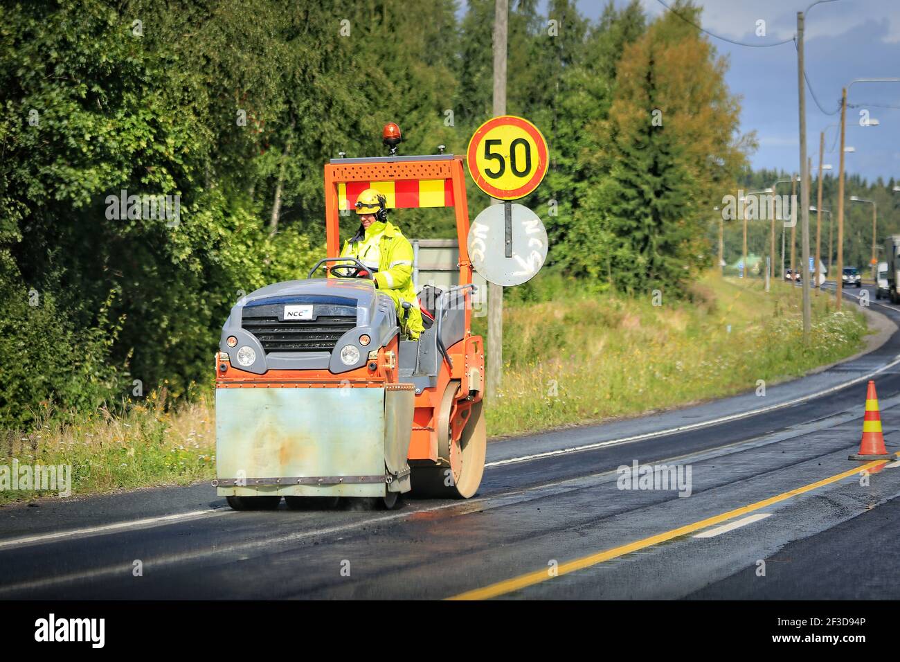 Straßenroller bei der Arbeit auf der Baustelle. Asphaltstraße im Sommer in Finnland. Stockfoto