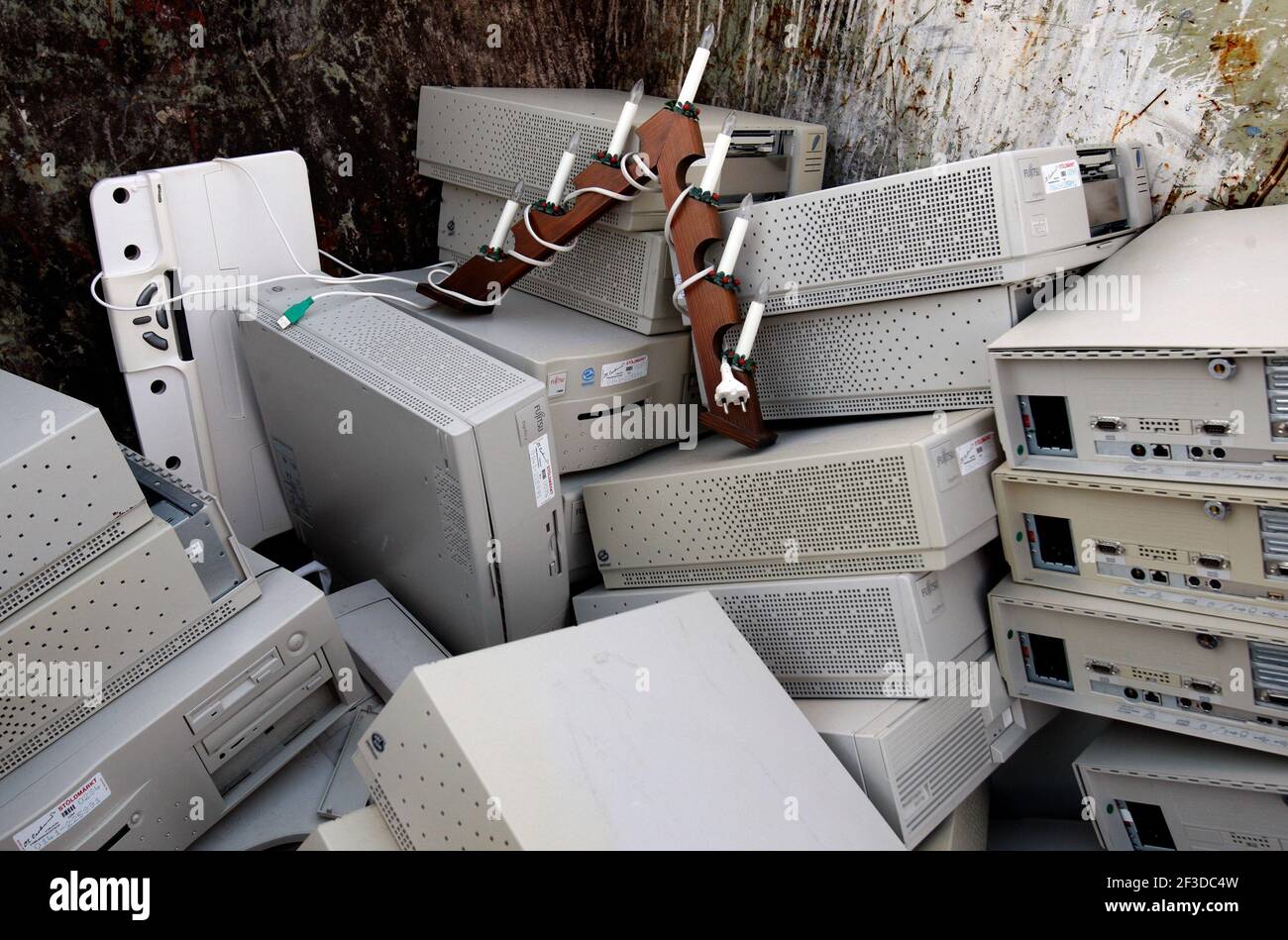 Elektronikschrott, alte Festplatten und Computer, die in einer kommunalen Deponie entsorgt werden, wo Müll weggeworfen werden kann. Auch ein Adventskerzleuchter wurde weggeworfen. Stockfoto