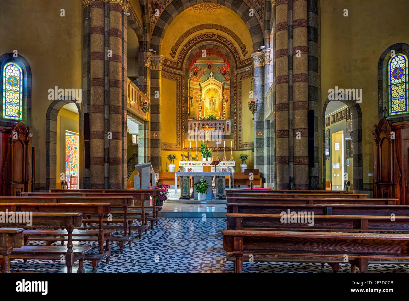 Holzbänke und Altar als Teil der Innenräume der Kirche Madonna della Moretta in Alba - kleine Stadt im Piemont, Italien. Stockfoto