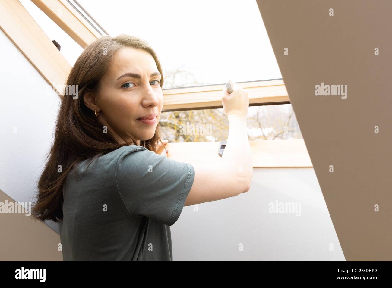Frauen öffnen ein Fenster im Home Office und lassen frische Luft hinein. Gesundes Arbeitsumfeld in den neuen normalen Geschäftszeiten. Stockfoto