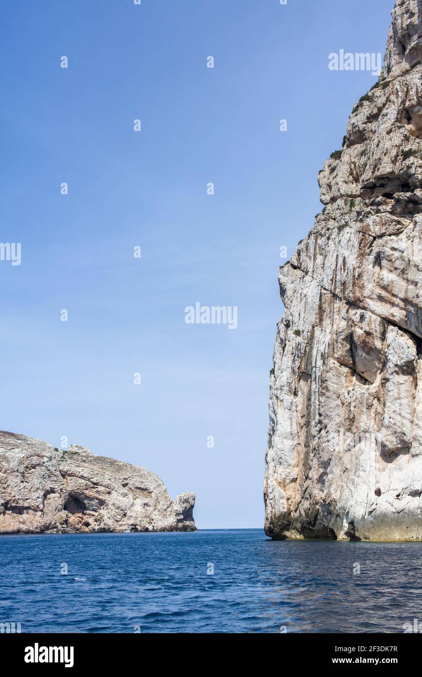 Küste mit Blick auf eine große Klippe vom Meer aus. Lage ist Porte Conte Regional National Park, Alghero Sardinien. Stockfoto