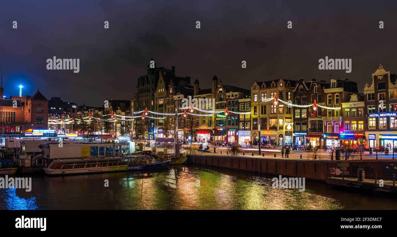 Damrak in Amsterdam bei Nacht in Holland, Niederlande Stockfoto