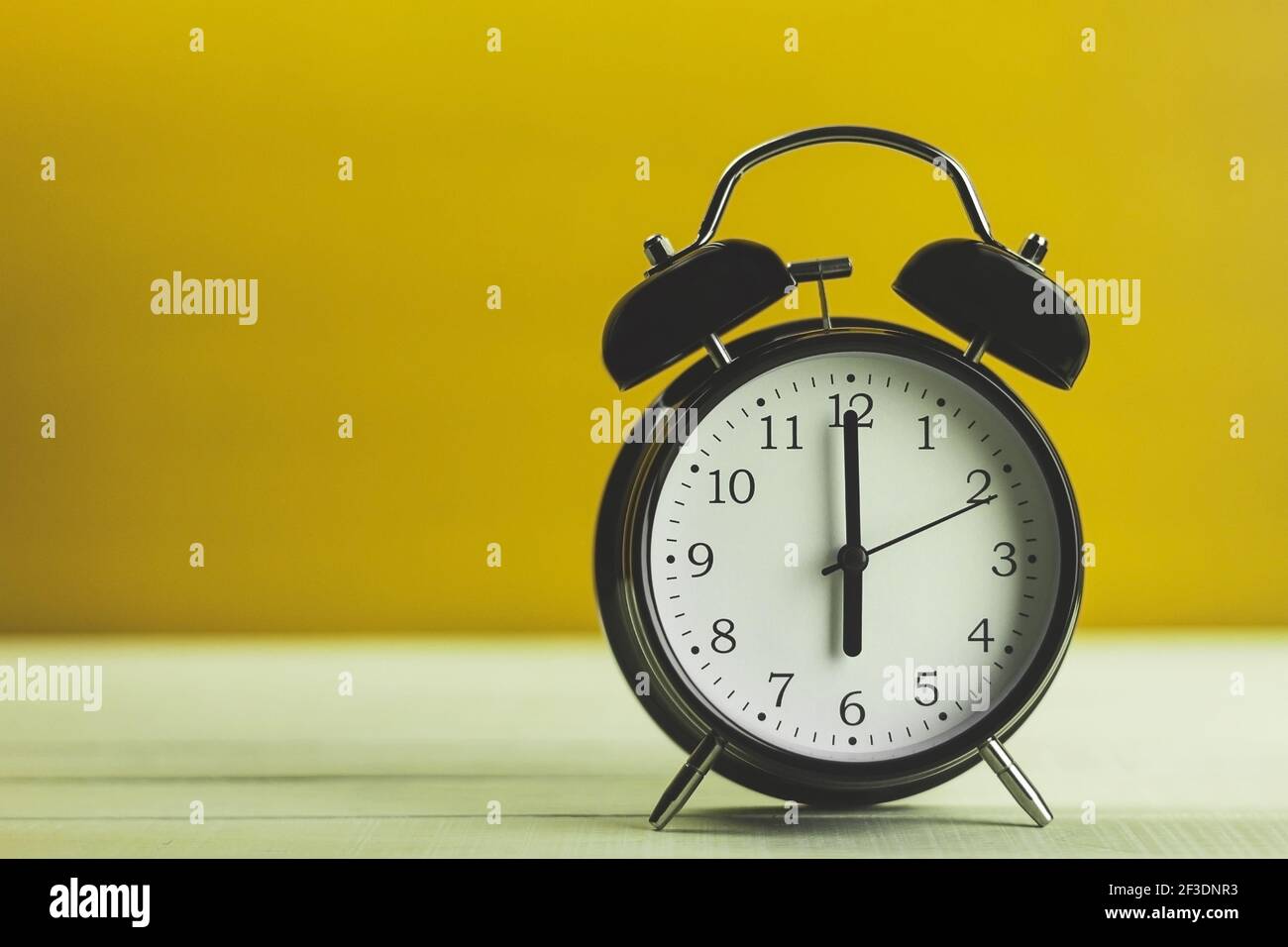 Wecker, auf dem sechs Uhr. Uhr im Vintage-Stil, 6 Uhr, auf dunklem Holzgrund. Platz für Text kopieren Stockfoto