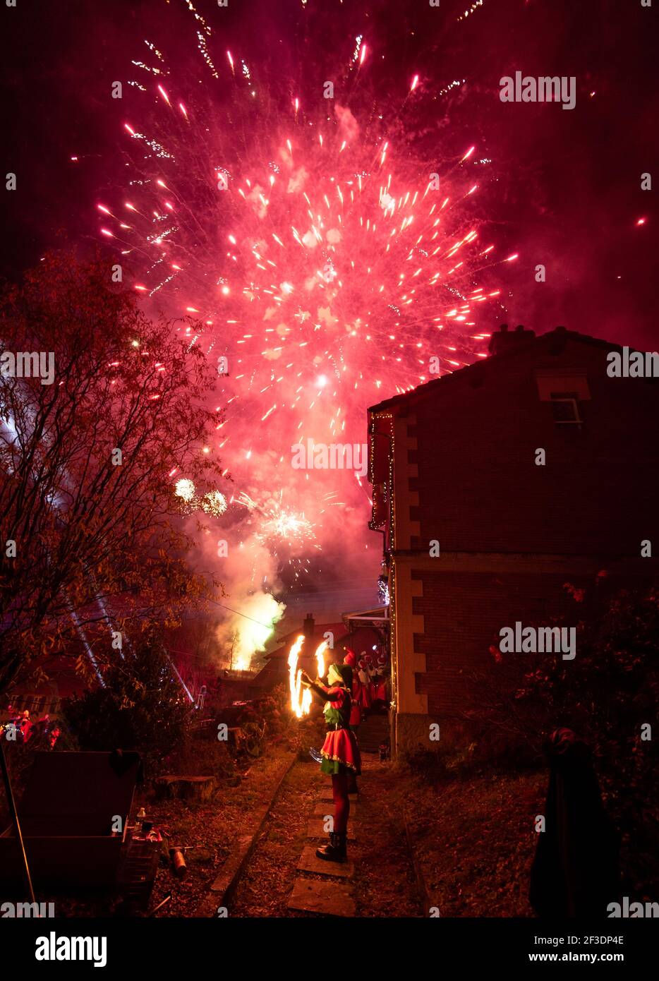 Weibliche santa mit Feuer unter Feuerwerk in Himmel auf heiligabend Stockfoto