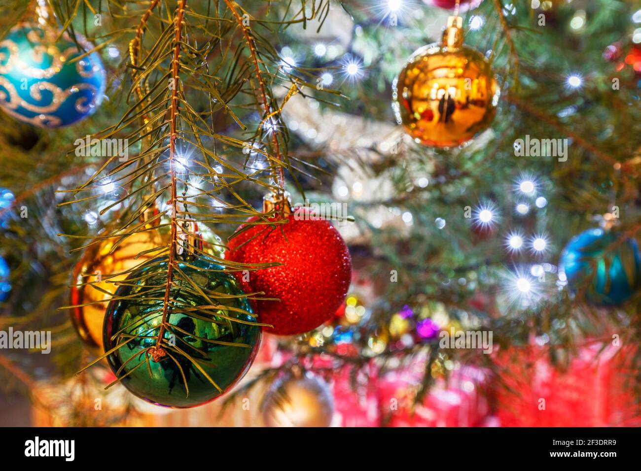 Saisonale Weihnachtsdekorationen, bunte Kugeln auf einem Weihnachtsbaum Stockfotografie
