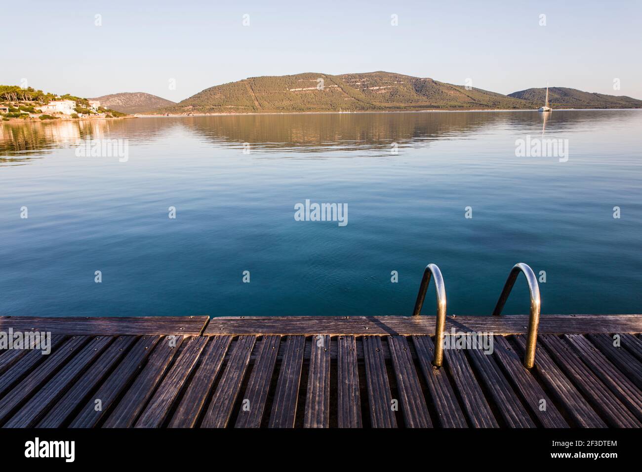 Das Porto Conte Marina befindet sich in einem Naturschutzgebiet in Porto Fertilia Alghero, Sardinien. Bild zeigt hölzerne Deckgangway mit Metallleitern Stockfoto