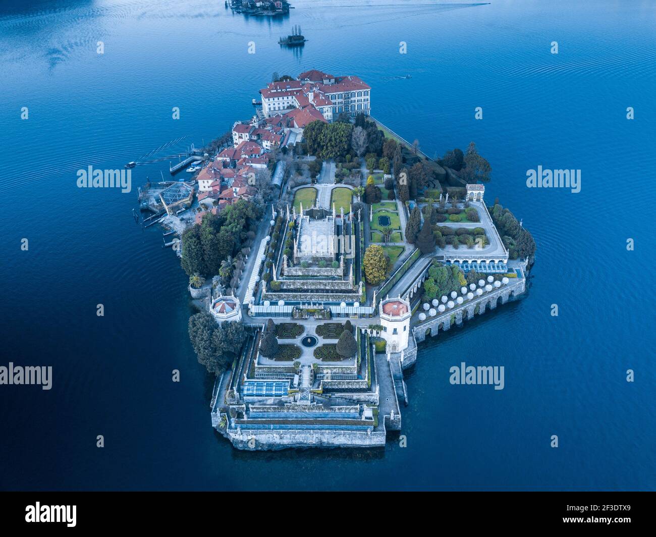 Luftaufnahme auf kleiner Insel mit Schloss und repräsentativstem Park. Alte Gebäude und schöne, gepflegte Gärten mitten im See. Stockfoto