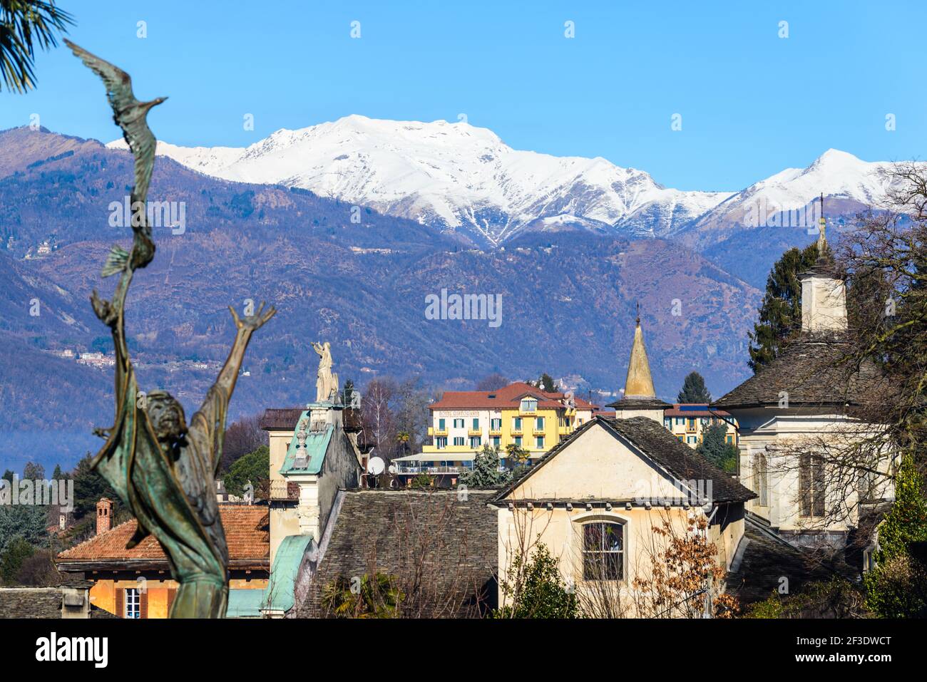 Beschnittene Ansicht von Gebäuden im historischen Teil der Stadt und schneebedeckter Bergrücken im Hintergrund. Der Himmel ist klar. Stockfoto