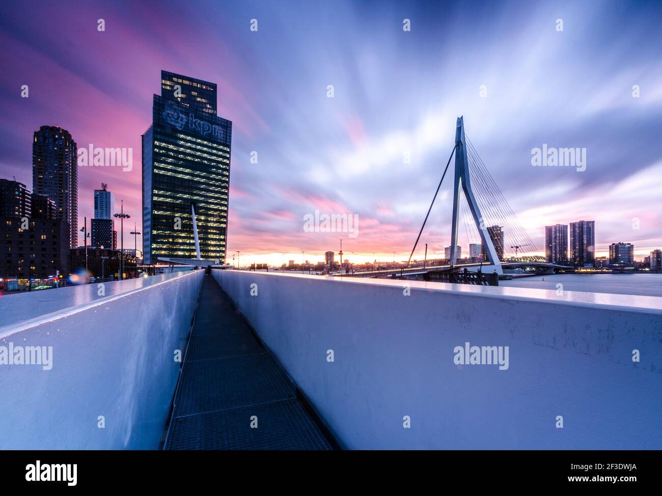 Malerischer, violetter Sonnenuntergang über der modernen Erasmus-Brücke in Rotterdam, Niederlande. Modernes Stadtpanorama. Stockfoto