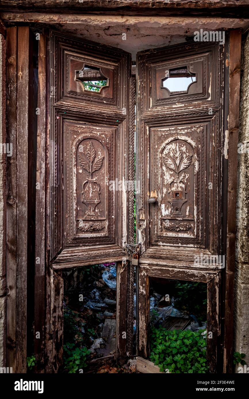 Alte traditionelle Holztür mit aufwendigen Reliefverdrängungen, in einem verlassenen Haus in Archanes Dorf, in der Nähe von Heraklion Stadt, auf Kreta, Griechenland Stockfoto