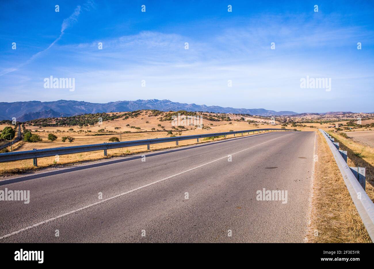 Leere Autobahn mit Barrieren. Landschaft mit blauem Himmel und Bergen in der Ferne Stockfoto