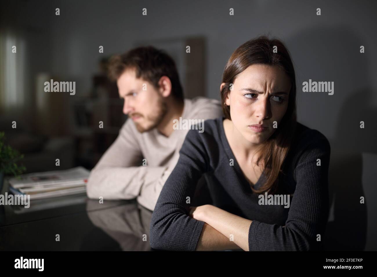 Verärgeres Paar, das sich gegenseitig ignoriert und im Wohnzimmer sitzt In der Nacht zu Hause Stockfoto